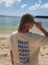Frau im T-Shirt am Strand in der Farbe Natur mit blauem Print Mare